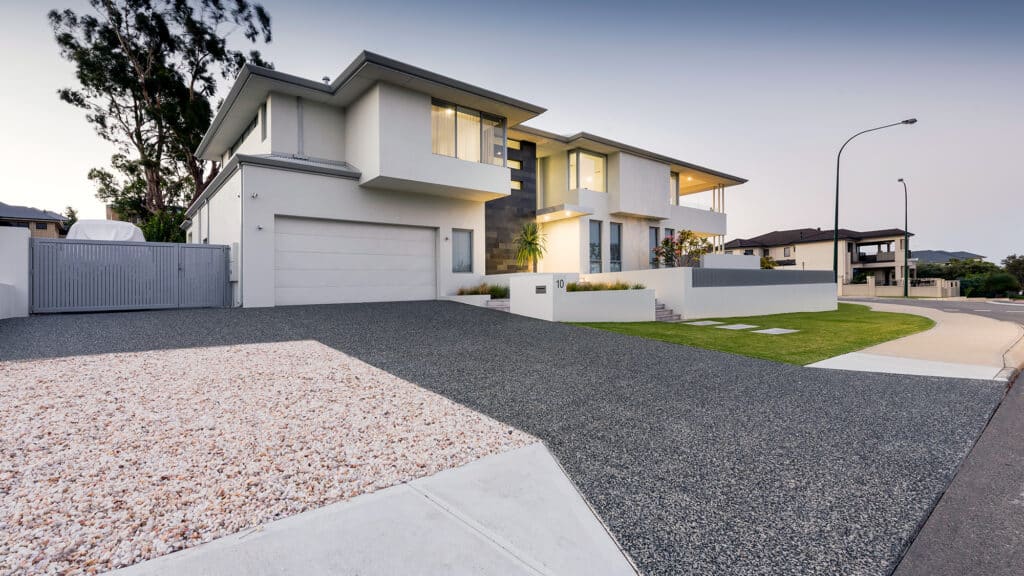 Exposed aggregate driveway in front of modern home