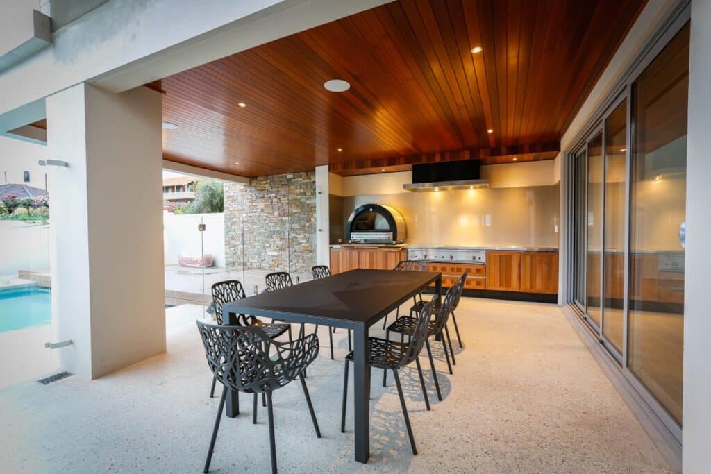 Outdoor alfresco kitchen and dining area with honed concrete floor