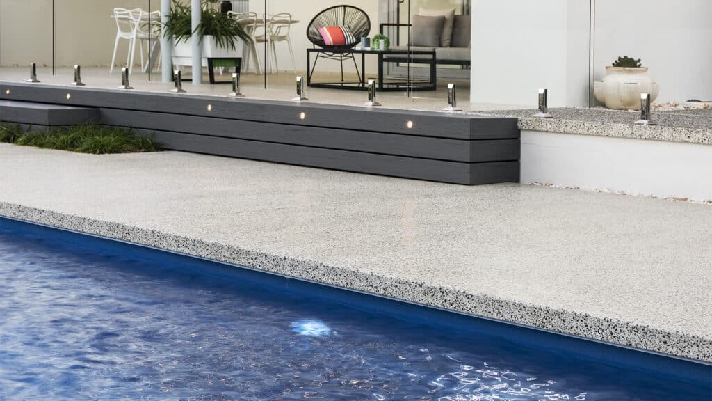 Honed concrete pool edge in front of outdoor alfresco